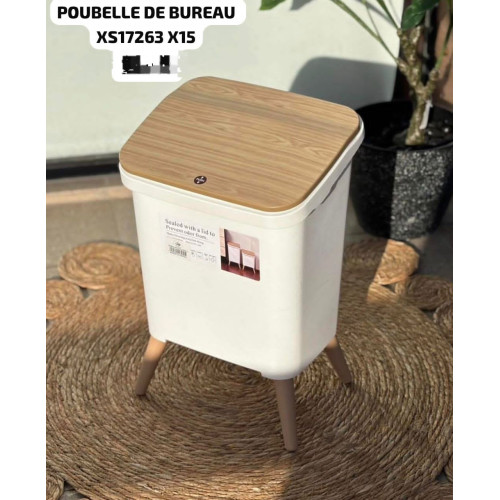 Poubelle de bureau blanche de style scandinave avec un couvercle effet bois clair et quatre pieds sur un sol en parquet