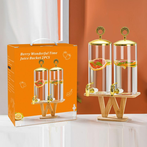 Double distributeur de boissons en verre avec robinets et couvercles dorés sur socle en bois contenant de la citronnade et du jus de fruits rouge.