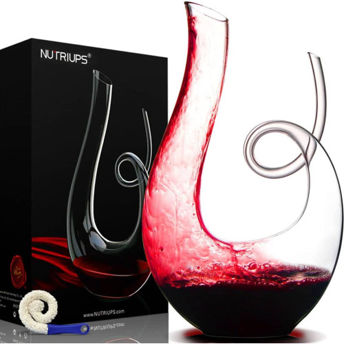 Décanteur à vin en cristal Nutriups rempli de vin rouge à côté de sa boîte d'origine. Décanteur à vin en cristal Nutriups rempli de vin rouge à côté de sa boîte d'origine.