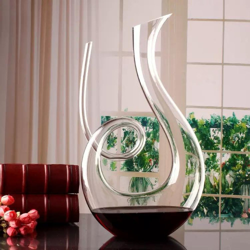 Décanteur à vin en cristal Nutriups rempli de vin rouge à côté de sa boîte d'origine. Décanteur à vin en cristal Nutriups rempli de vin rouge à côté de sa boîte d'origine.