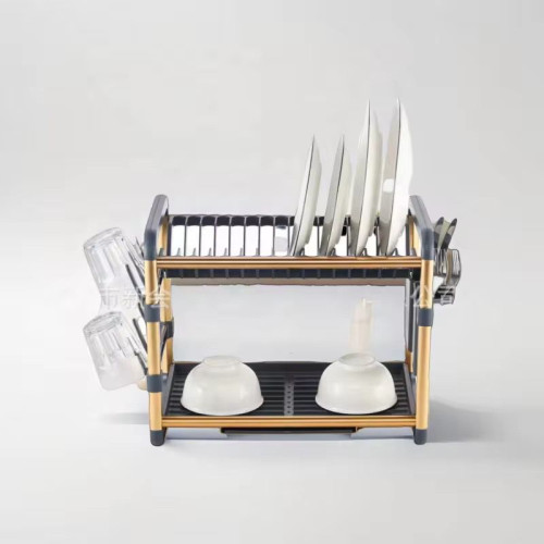 Égouttoir à vaisselle à deux niveaux de couleur gris et blanc posé sur un plan de travail en marbre et rempli d'assiettes, de bols et de verres