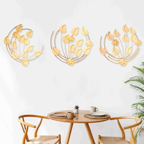 Grande décoration murale circulaire en métal doré brillant installée sur un mur rouge au-dessus d'un canapé moderne.