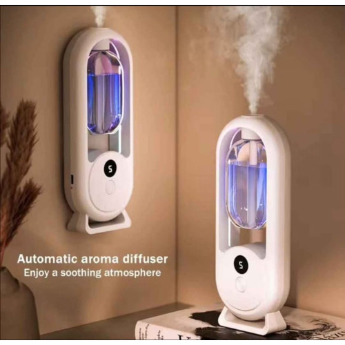 Humidificateur d air blanc à ultrasons diffusant une brume verticale avec veilleuse colorée et écran digital posé entre des vases