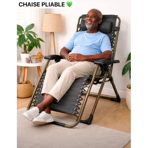 Chaise longue pliante inclinable vert kaki de type gravite zéro avec appui tète installée dans un salon de coiffure ou une maison