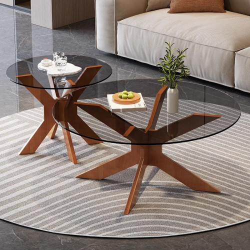 Ensemble de deux tables basses gigognes rondes avec plateaux en verre fumé et pieds en bois sur un tapis rayé.