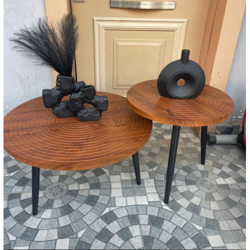 Set de deux tables basses gigognes rondes en bois sculpté de cernes d'arbre avec pieds noirs devant une entrée.