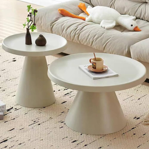 tables-basses-gigognes-rondes-blanches-tulipe-70-cm-et-50-cm Set de deux tables basses gigognes rondes de couleur blanche sur un tapis texturé devant un canapé crème.