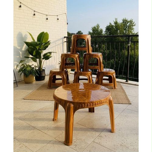 Ensemble de mobilier de terrasse en plastique brillant marron composé d'une table basse ronde et de sept tabourets empilés en pyramide sur un tapis