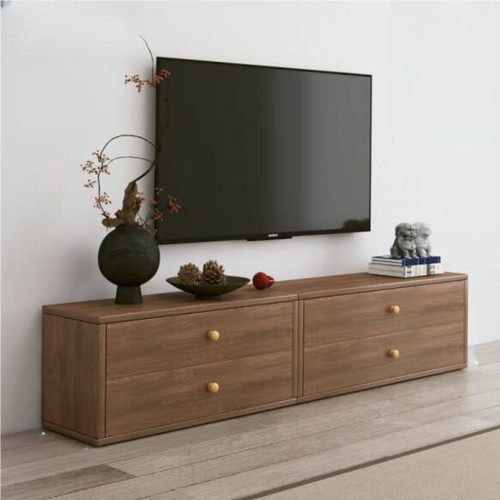 Long meuble TV moderne en bois marron a quatre tiroirs sous un grand écran plat fixe au mur dans un salon lumineux