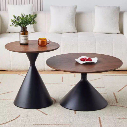 Duo de tables basses gigognes avec plateaux en bois et pieds coniques noirs devant un canapé blanc.