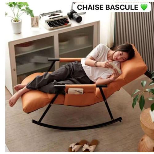 chaise-bascule-relaxante-orange-design Fauteuil à bascule relaxant orange avec rembourrage épais et structure en métal noir sur un tapis de salon.