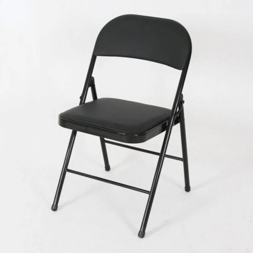 Chaise pliante rembourrée noire en simili cuir et métal sur un sol en bois