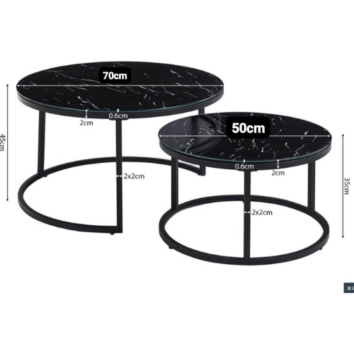Set de deux tables basses gigognes rondes avec plateaux effet marbre noir et pieds en métal noir devant un canapé.