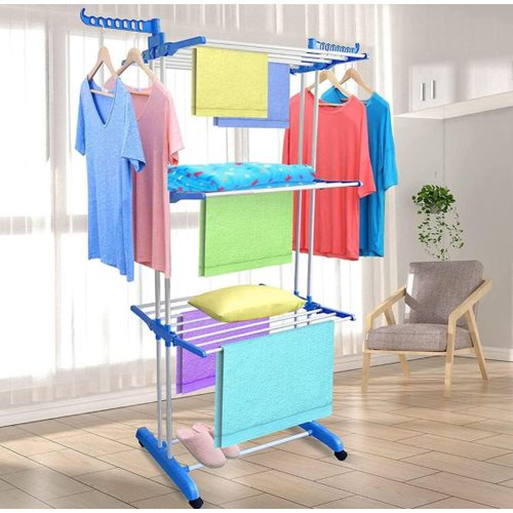 Grand étendoir à linge vertical bleu et inox à trois niveaux garni de vêtements et serviettes dans un salon