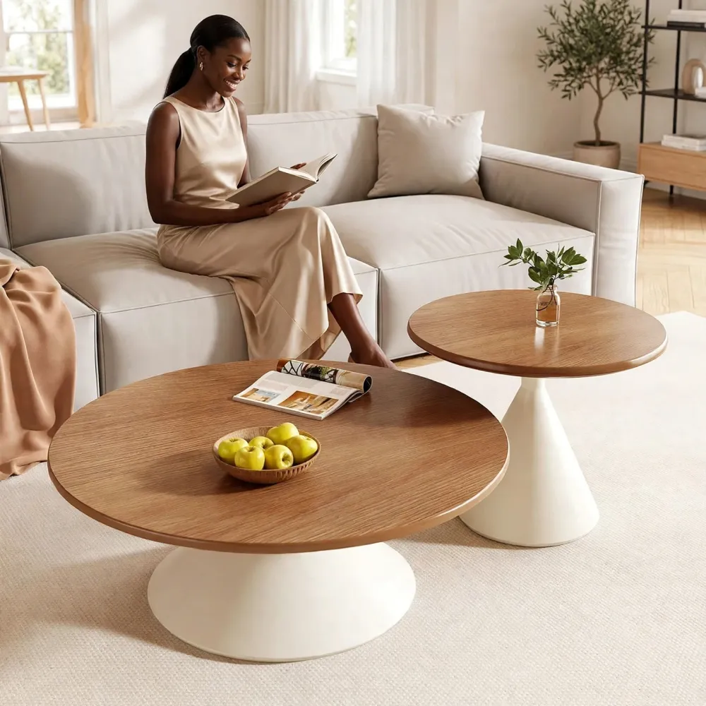 Deux tables basses rondes de tailles différentes avec plateau en bois clair et pied central évasé blanc sur un tapis