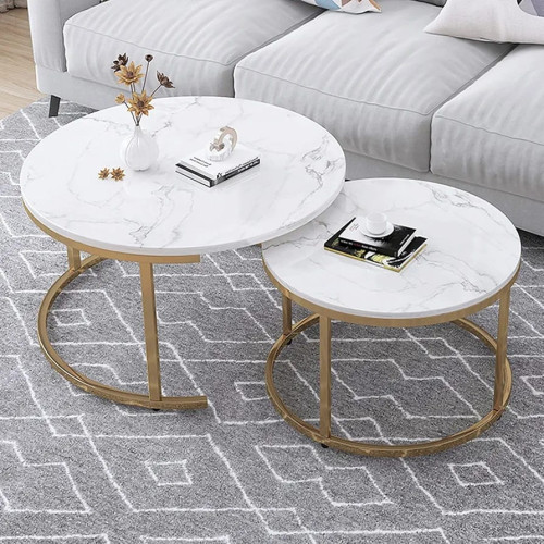tables-basses-gigognes-marbre-blanc-or Set de deux tables basses gigognes rondes avec plateaux effet marbre blanc et pieds dorés sur un tapis géométrique gris devant un canapé.
