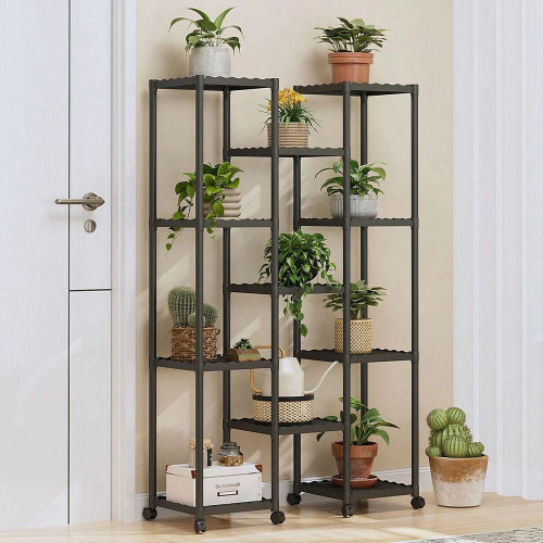 Étagère porte plante noire à roulettes sur plusieurs niveaux garnie de pots de fleurs et cactus dans un salon