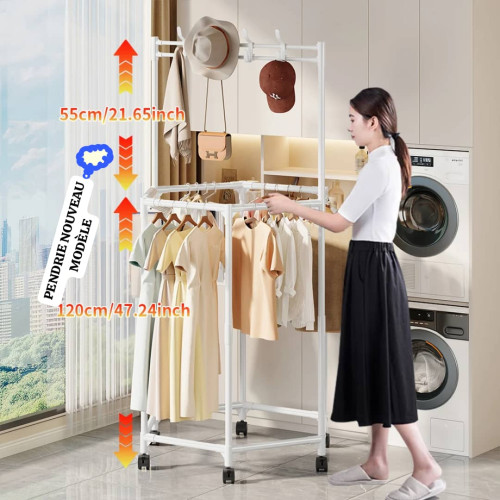 Portant à vêtements rotatif en métal noir sur roulettes chargé de robes et hauts avec des chapeaux et un sac suspendus sur la partie supérieure
