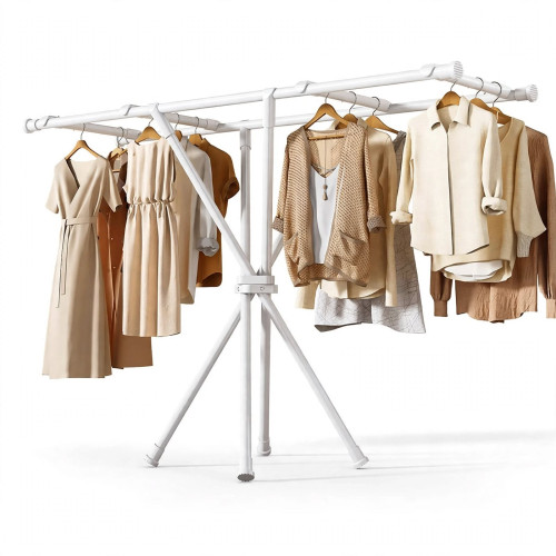 Séchoir à linge trépied en métal blanc installé sur fond blanc avec de nombreuses robes et chemises suspendues sur des cintres en bois