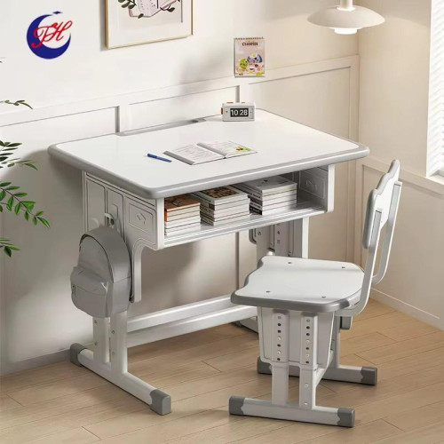 Table d'étude et chaise réglable enfant blanc et gris Enfant assis écrivant sur un bureau d'étude ergonomique blanc et gris réglable en hauteur avec sac suspendu