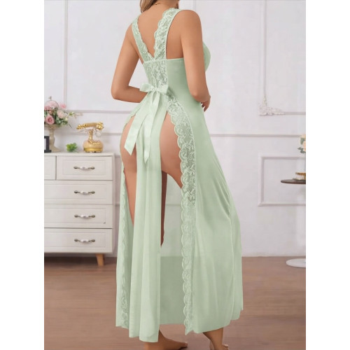 Nuisette longue vert sauge voile et dentelle Femme debout portant une longue nuisette vert sauge transparente en voile et dentelle sur le décolleté avec un grand nœud en satin à la taille
