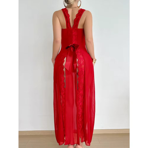 Femme debout portant une longue nuisette rouge passion transparente en voile et dentelle sur le décolleté avec un grand nœud en satin à la taille